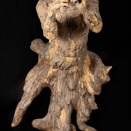 Male figure made of wood and bark playing a wind instrument.